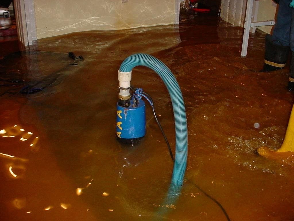 Standing water being removed from a basement